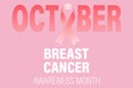 Symbol of breast cancer awareness month in October. Pink ribbon in the word October on a pink background.